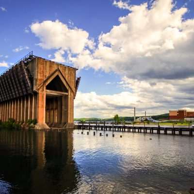 Historic ore dock by the lakeside under cloudy sky.