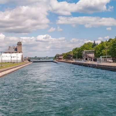 Canal with trees and cloudy sky